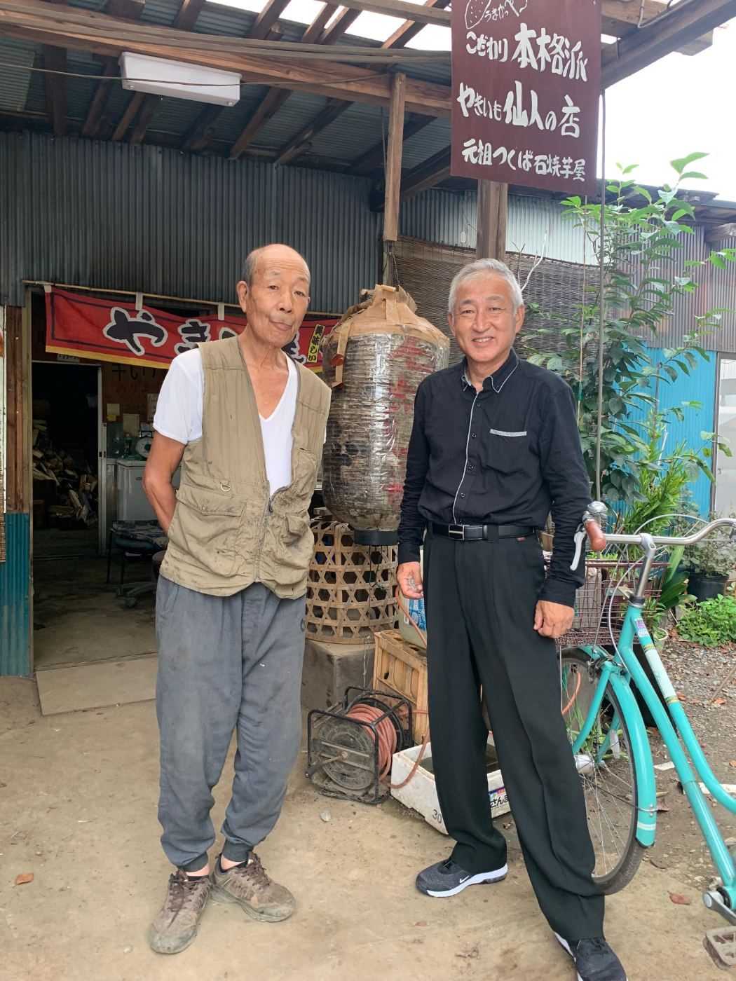 つくば「やきいも仙人の店」の前に立つ、松本義男さんと店主・松村